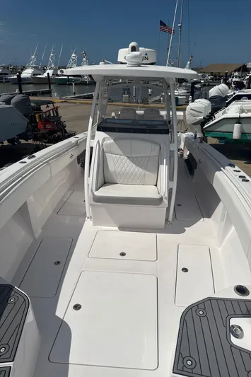  Yacht Photos Pics 2018 Fountain 38cc boat with spacious deck and seating, docked at marina.