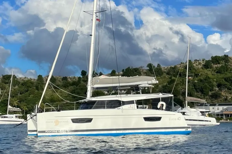  Yacht Photos Pics 2019 Fountaine Pajot Lucia 40 catamaran sailing on a scenic waterway.