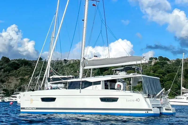 Yacht Photos Pics 2019 Fountaine Pajot Lucia 40 catamaran sailing on a serene blue sea.