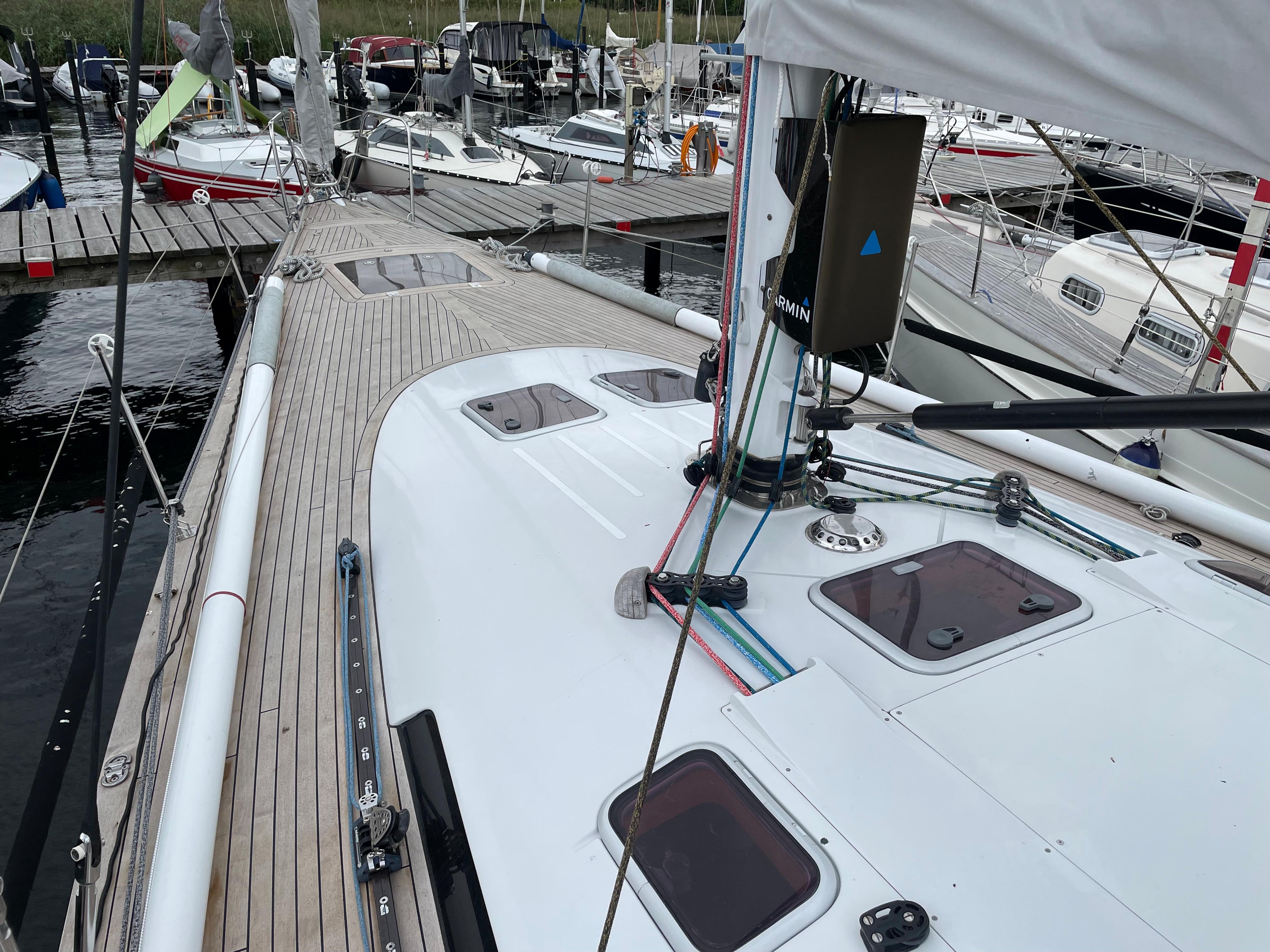 Sailboat Comet 45 S, 2005 model, docked in marina with wooden deck and visible rigging.