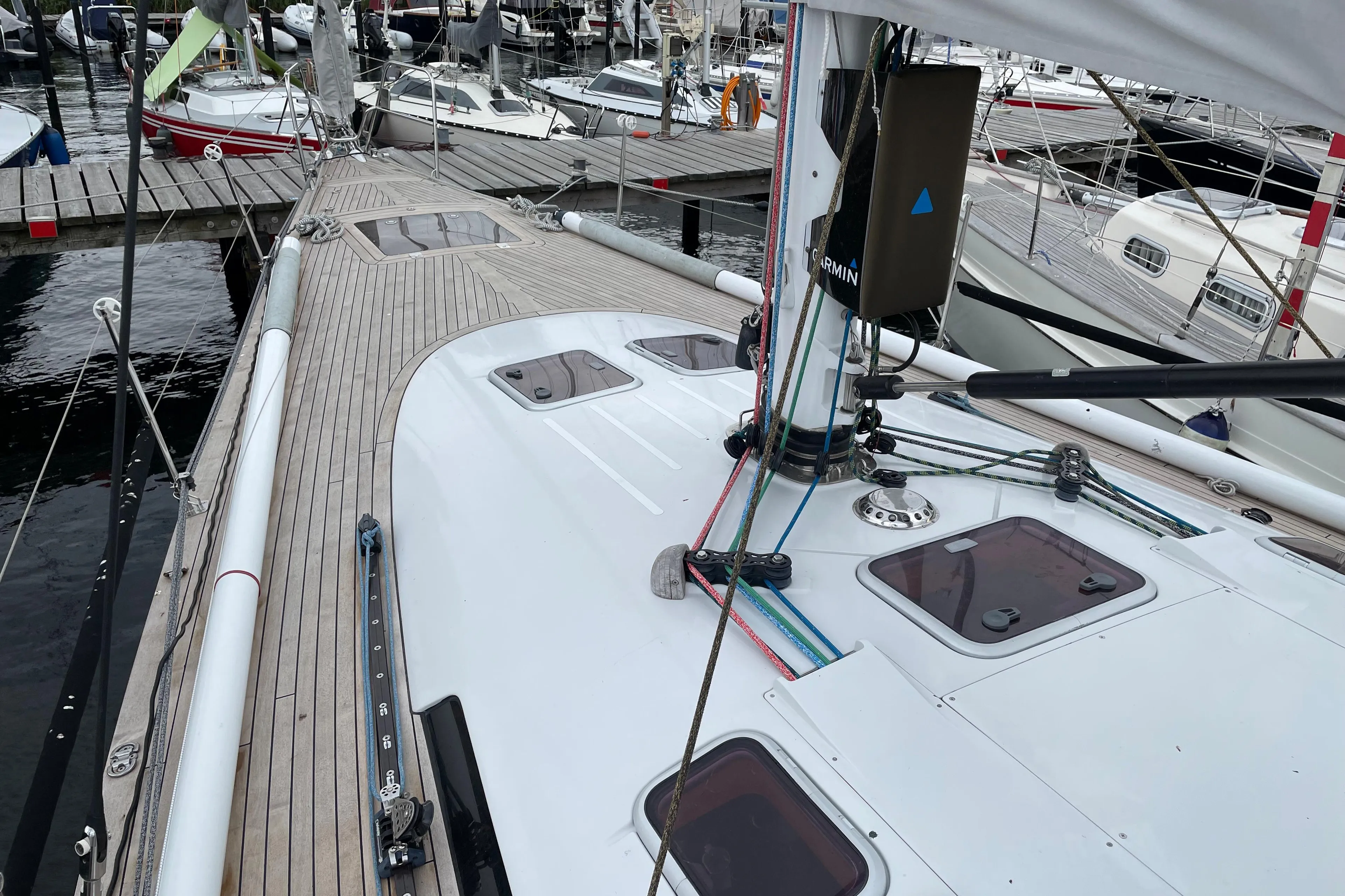 Sailboat Comet 45 S, 2005 model, docked in marina with wooden deck and visible rigging.