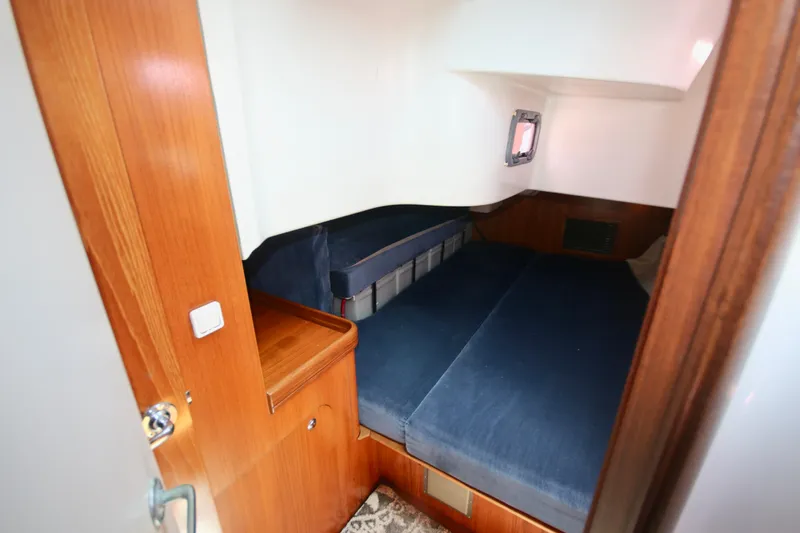 Exfil Yacht Photos Pics 1998 Beneteau Oceanis 461 cabin with blue cushions and wooden interior.