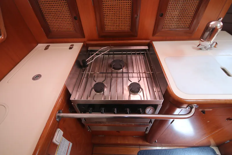 Exfil Yacht Photos Pics 1998 Beneteau Oceanis 461 yacht kitchen with stove and wooden cabinetry.