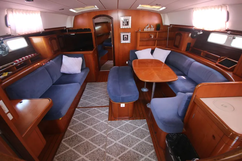 Exfil Yacht Photos Pics Interior of 1998 Beneteau Oceanis 461 yacht with blue seating and wooden finishes.