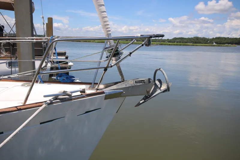Exfil Yacht Photos Pics Beneteau Oceanis 461 sailboat bow with anchor, docked on calm water, 1998 model.