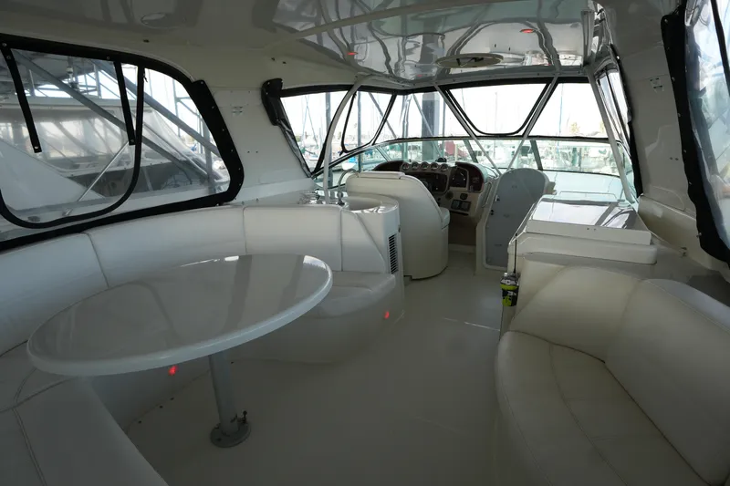So Far Yacht Photos Pics Interior of 2004 Carver 560 Voyager yacht with white seating and helm station.