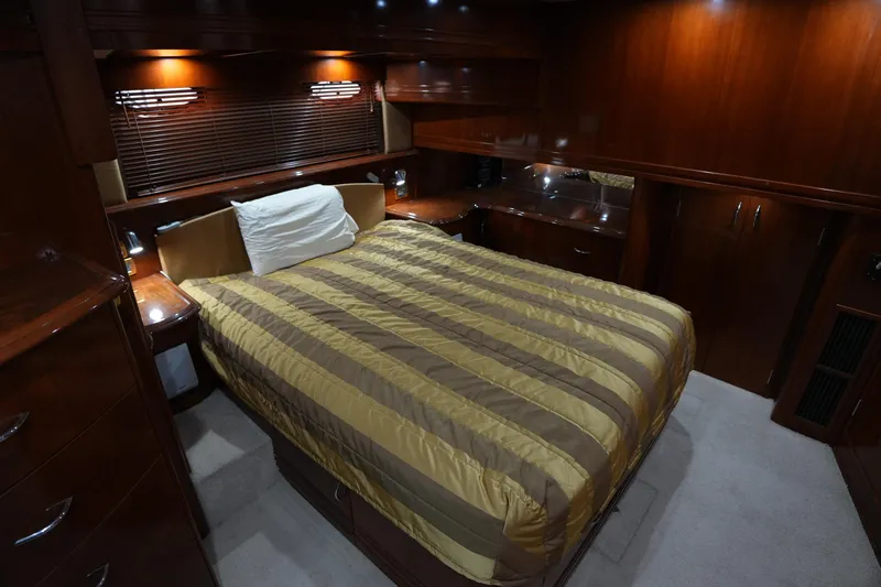 So Far Yacht Photos Pics Luxurious bedroom interior of 2004 Carver 560 Voyager yacht with wood paneling.