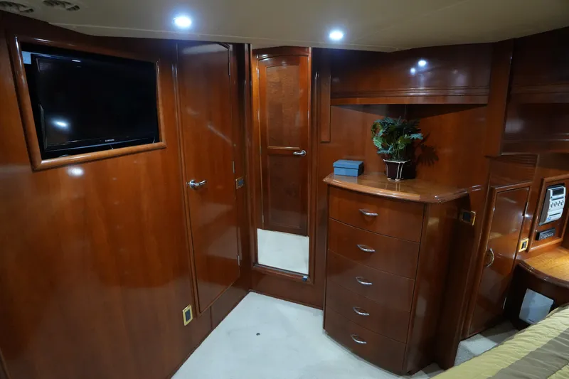 So Far Yacht Photos Pics Luxurious 2004 Carver 560 Voyager cabin with wood finish, TV, and dresser.