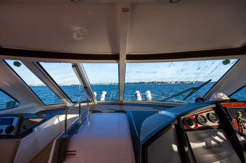 Epic Yacht Photos Pics Interior view of 2013 Cruisers Yachts 540 Sports Coupe, showcasing helm and ocean scenery.