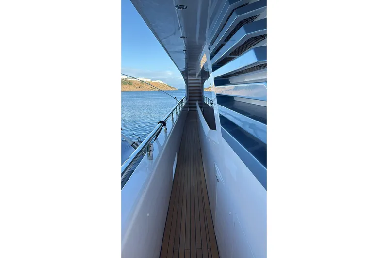 Elza Of London Yacht Photos Pics Side deck view of 2015 Majesty 122 yacht, featuring sleek design and ocean backdrop.