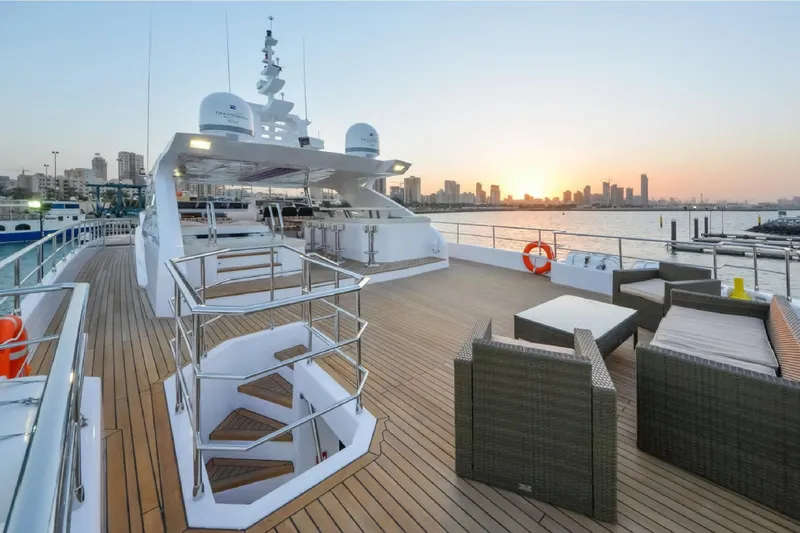 Elza Of London Yacht Photos Pics Luxurious Majesty 122 yacht deck at sunset, featuring elegant seating and city skyline views.