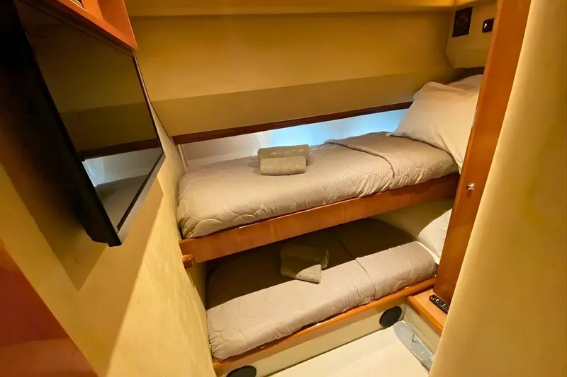 M/y Okiyo Yacht Photos Pics Cozy twin bunk beds in 2002 Ferretti Yachts 68 cabin, featuring warm lighting and modern amenities.