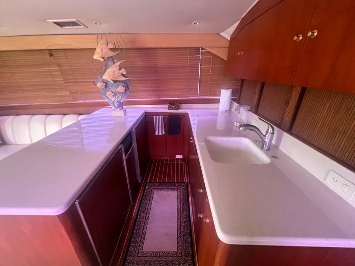 Fender Bender Yacht Photos Pics Interior of 1996 Ocean Yachts 48 Super Sport, featuring a modern kitchen with wooden cabinetry.