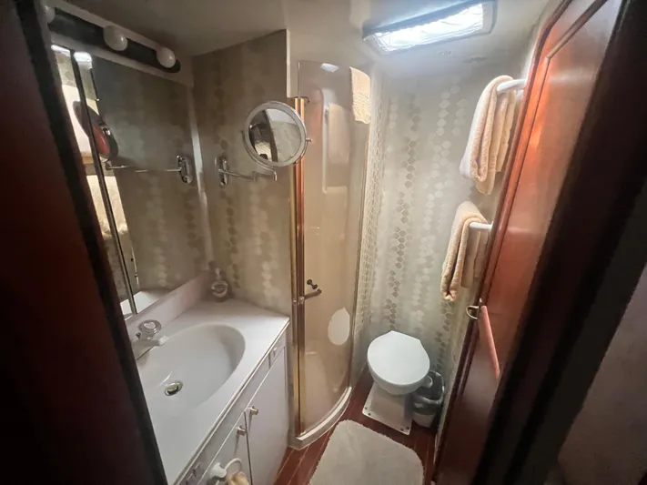 Fender Bender Yacht Photos Pics Bathroom interior of 1996 Ocean Yachts 48 Super Sport, featuring shower, sink, and toilet.