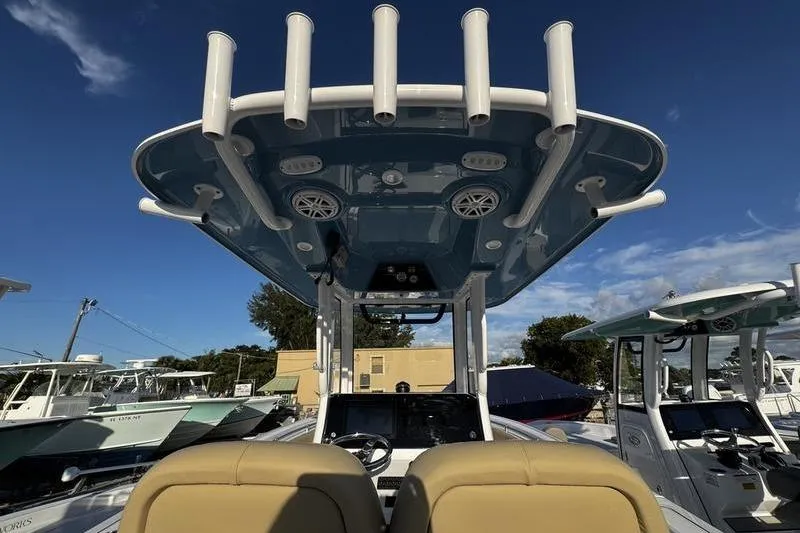  Yacht Photos Pics 2026 Sportsman Open 252 Center Console boat with rod holders and electronics, under clear blue sky.