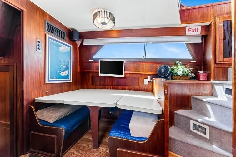 The Entertainer Yacht Photos Pics Interior of 1984 Hatteras 61 Cockpit MY, featuring dining area with table and seating.