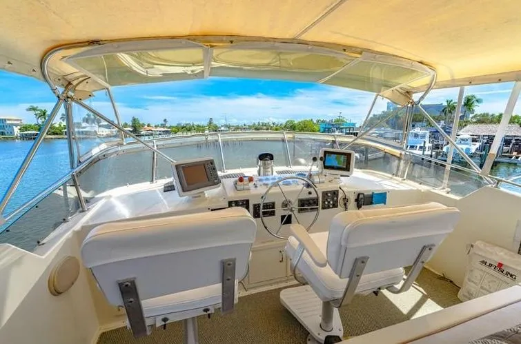 The Entertainer Yacht Photos Pics Cockpit view of 1984 Hatteras 61 yacht with dual seats and navigation equipment.