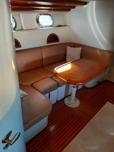  Yacht Photos Pics Interior of 1997 Otam 45 yacht with leather seating and wooden table.