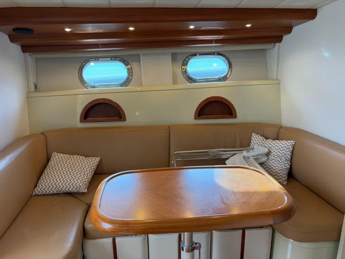  Yacht Photos Pics Interior of 1997 Otam 45 yacht with cozy seating and wooden table.