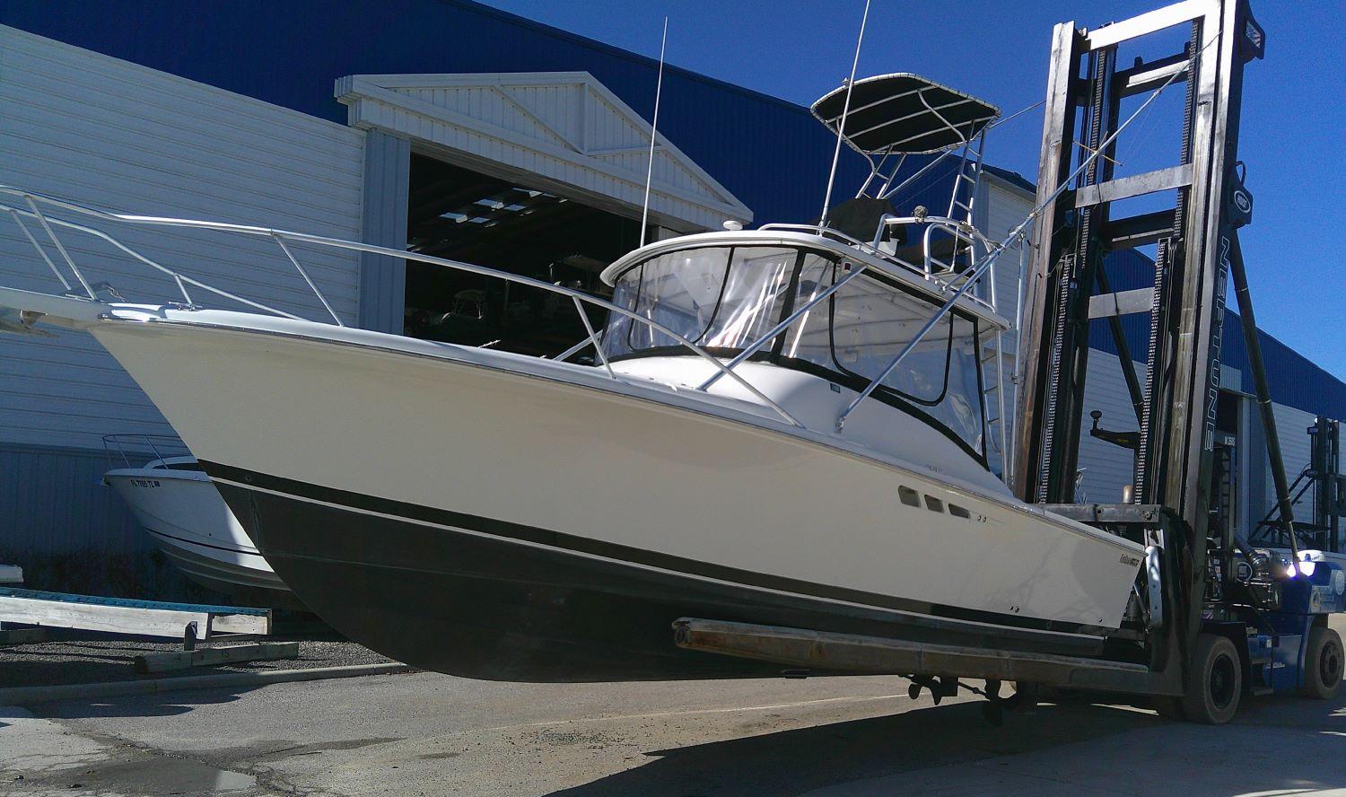 2000 Luhrs Tournament 290 Open boat on forklift near warehouse.