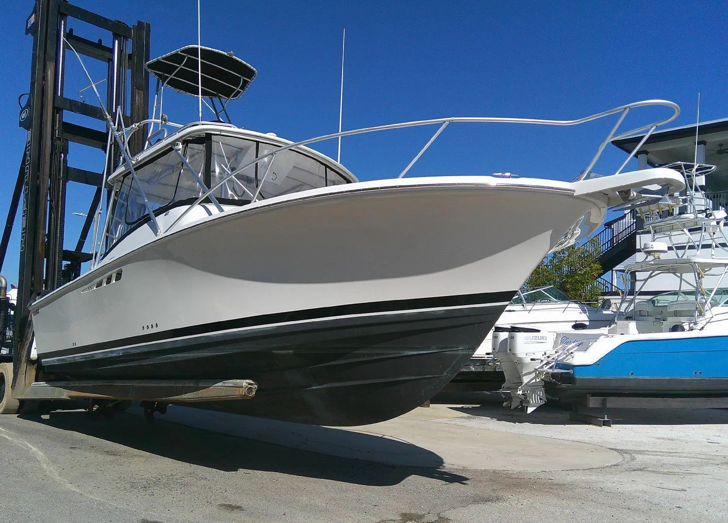 2000 Luhrs Tournament 290 Open boat on forklift, white hull, marina background.