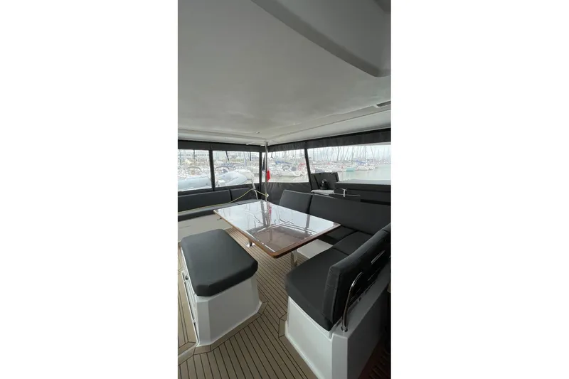 Maeva Yacht Photos Pics 2023 Fountaine Pajot Catamaran Aura 51 interior with sleek seating and table.