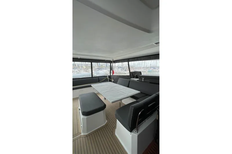 Maeva Yacht Photos Pics 2023 Fountaine Pajot Catamaran Aura 51 interior with seating and table, showcasing modern design.