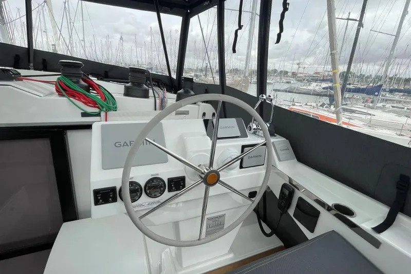 Maeva Yacht Photos Pics Helm of 2023 Fountaine Pajot Catamaran Aura 51 with navigation equipment and marina view.