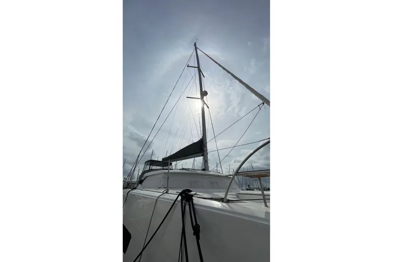 Maeva Yacht Photos Pics 2023 Fountaine Pajot Catamaran Aura 51 with sails against a bright sky.
