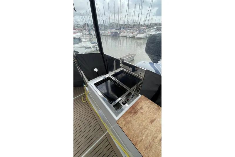 Maeva Yacht Photos Pics 2023 Fountaine Pajot Catamaran Aura 51 with outdoor cooking area, docked at marina.