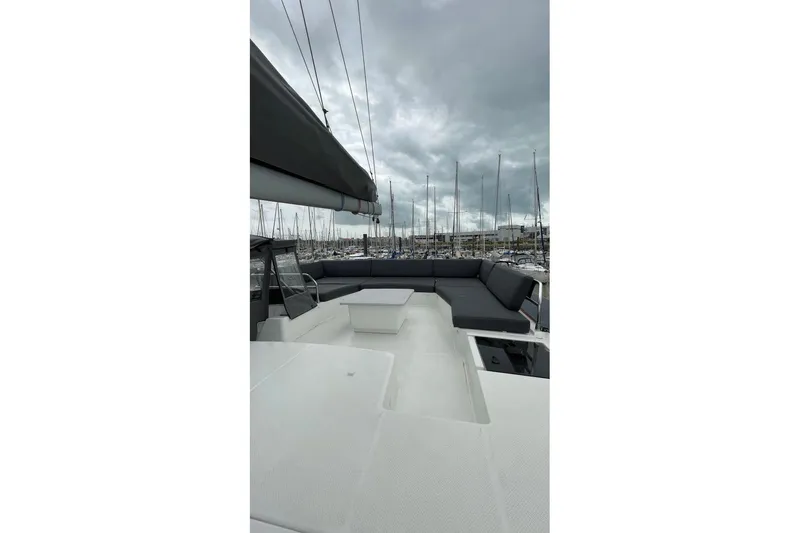 Maeva Yacht Photos Pics 2023 Fountaine Pajot Catamaran Aura 51 deck with seating, under cloudy sky.