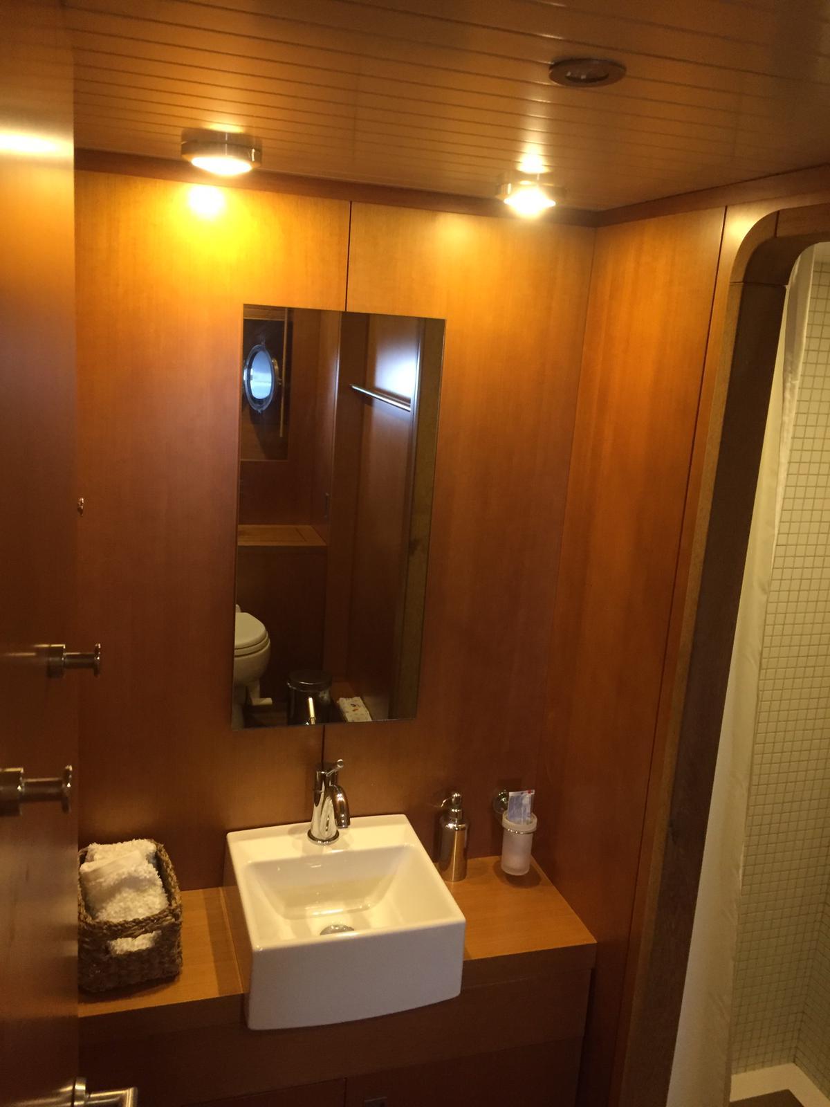 Luxurious wooden bathroom interior on 2005 Explorer 70' yacht with modern sink and mirror.