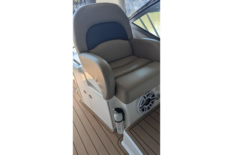  Yacht Photos Pics Captain's chair on 2004 Sea Ray 340 Sundancer boat, featuring tan upholstery and teak flooring.