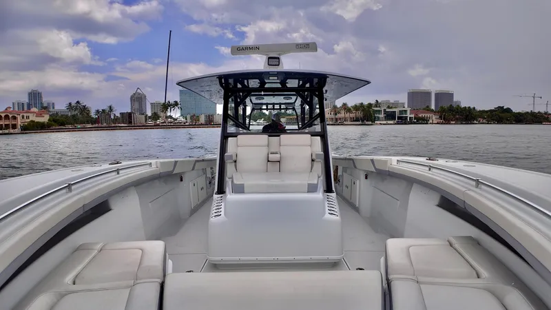  Yacht Photos Pics 2022 Yellowfin 42 Offshore boat on calm water, city skyline in background.