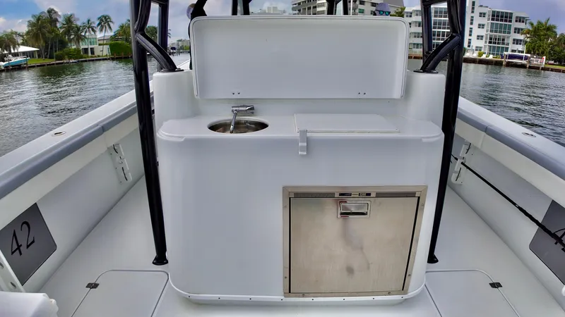  Yacht Photos Pics 2022 Yellowfin 42 Offshore boat interior with sink and storage, docked by waterfront homes.