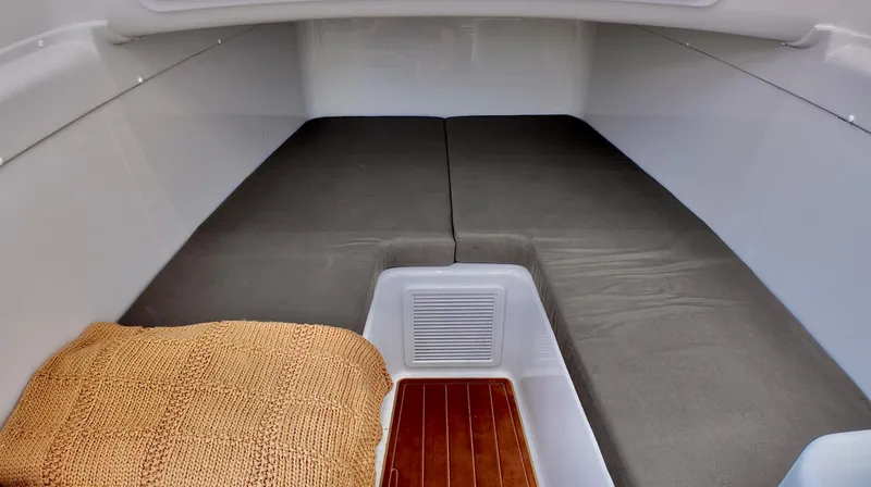  Yacht Photos Pics 2022 Yellowfin 42 Offshore cabin interior with cushioned seating and wooden flooring.
