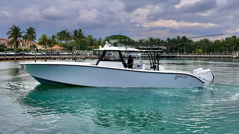  Yacht Photos Pics 2022 Yellowfin 42 Offshore boat on turquoise water with palm trees in the background.