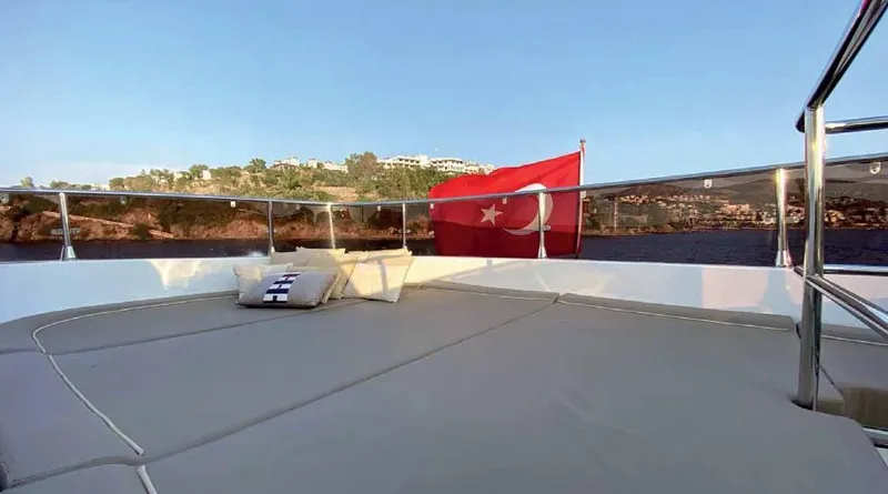 Vedo Yacht Photos Pics Luxurious Bilgin 30-meter yacht deck with Turkish flag, 2004 model, scenic coastal view.