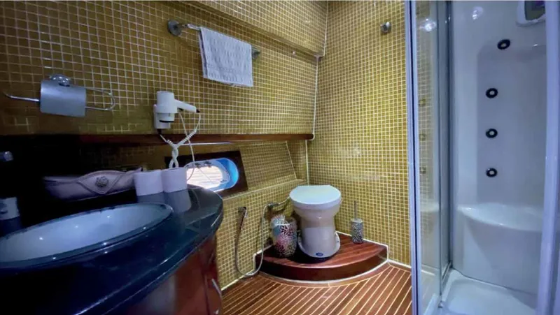 Vedo Yacht Photos Pics Luxurious yacht bathroom with modern amenities, featuring a shower, sink, and toilet. Bilgin 30 meter, 2004.
