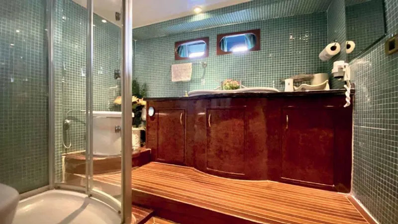 Vedo Yacht Photos Pics Luxurious yacht bathroom with wooden cabinetry, glass shower, and mosaic tiles, Bilgin 30 meter, 2004.