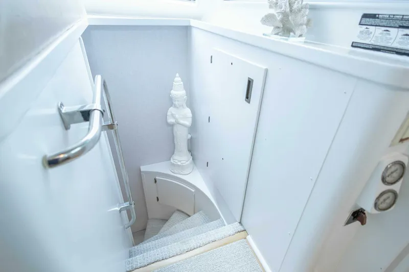  Yacht Photos Pics Staircase on 1989 Hatteras Custom Cockpit yacht with decorative statue and white interior.