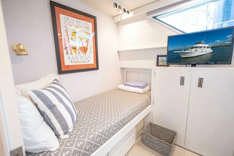  Yacht Photos Pics Cozy cabin interior of 1989 Hatteras Custom Cockpit yacht with bed, TV, and nautical decor.