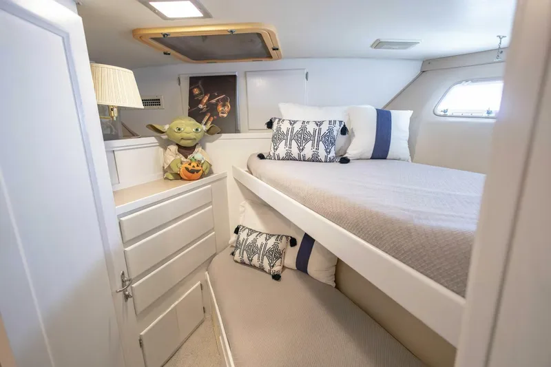  Yacht Photos Pics 1989 Hatteras Custom Cockpit cabin with cozy bed, decorative pillows, and playful decor.