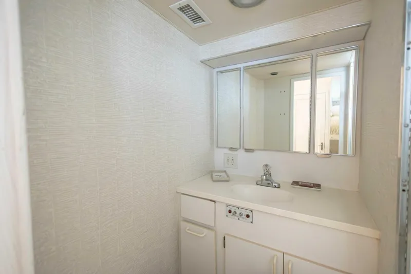  Yacht Photos Pics 1989 Hatteras Custom Cockpit bathroom with white vanity and mirrored cabinet.