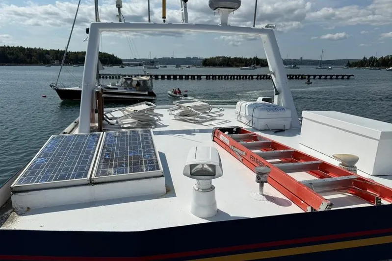  Yacht Photos Pics Boat deck with solar panels and equipment, LEBLANC Leo 38, 2000 model, docked in a scenic harbor.