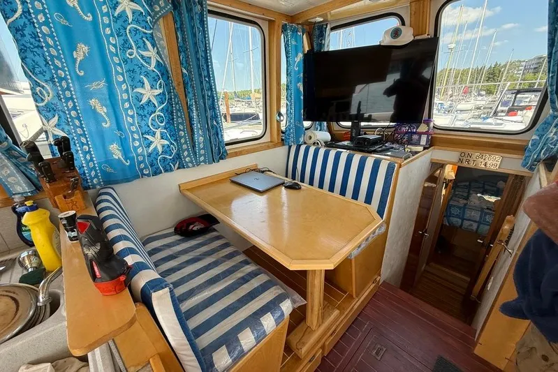  Yacht Photos Pics Interior of 2000 LEBLANC Leo 38 boat with striped seating and nautical-themed curtains.