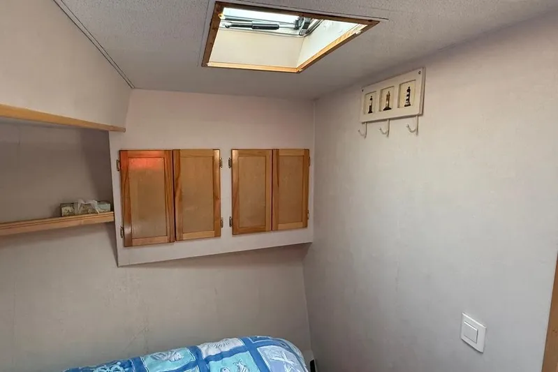  Yacht Photos Pics Cozy cabin interior of 2000 LEBLANC Leo 38 with wooden cabinets and skylight.