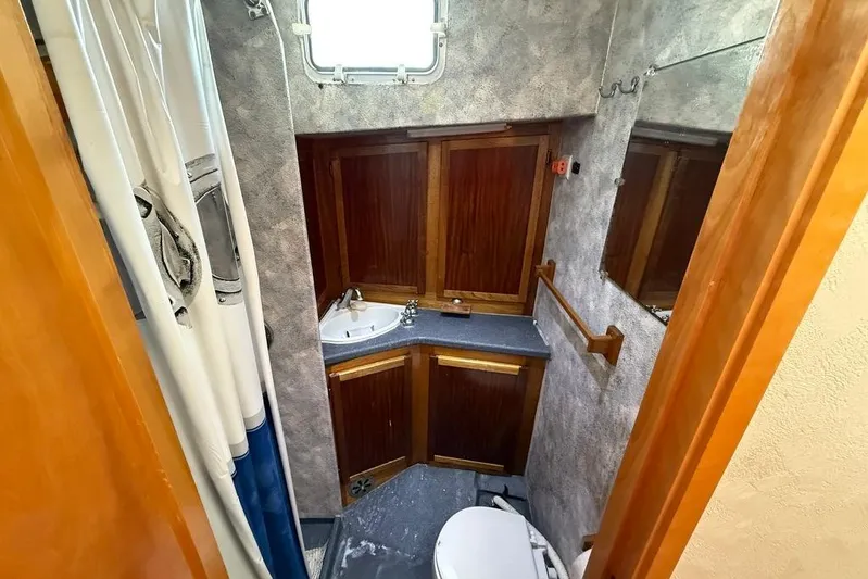  Yacht Photos Pics Compact bathroom in 2000 LEBLANC Leo 38 boat with wooden cabinets and shower.