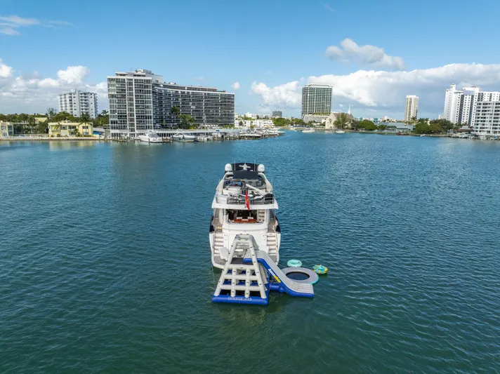 So What Who Cares Yacht Photos Pics Sunseeker 150 GT yacht with water slide, 2003 model, in a scenic urban marina.