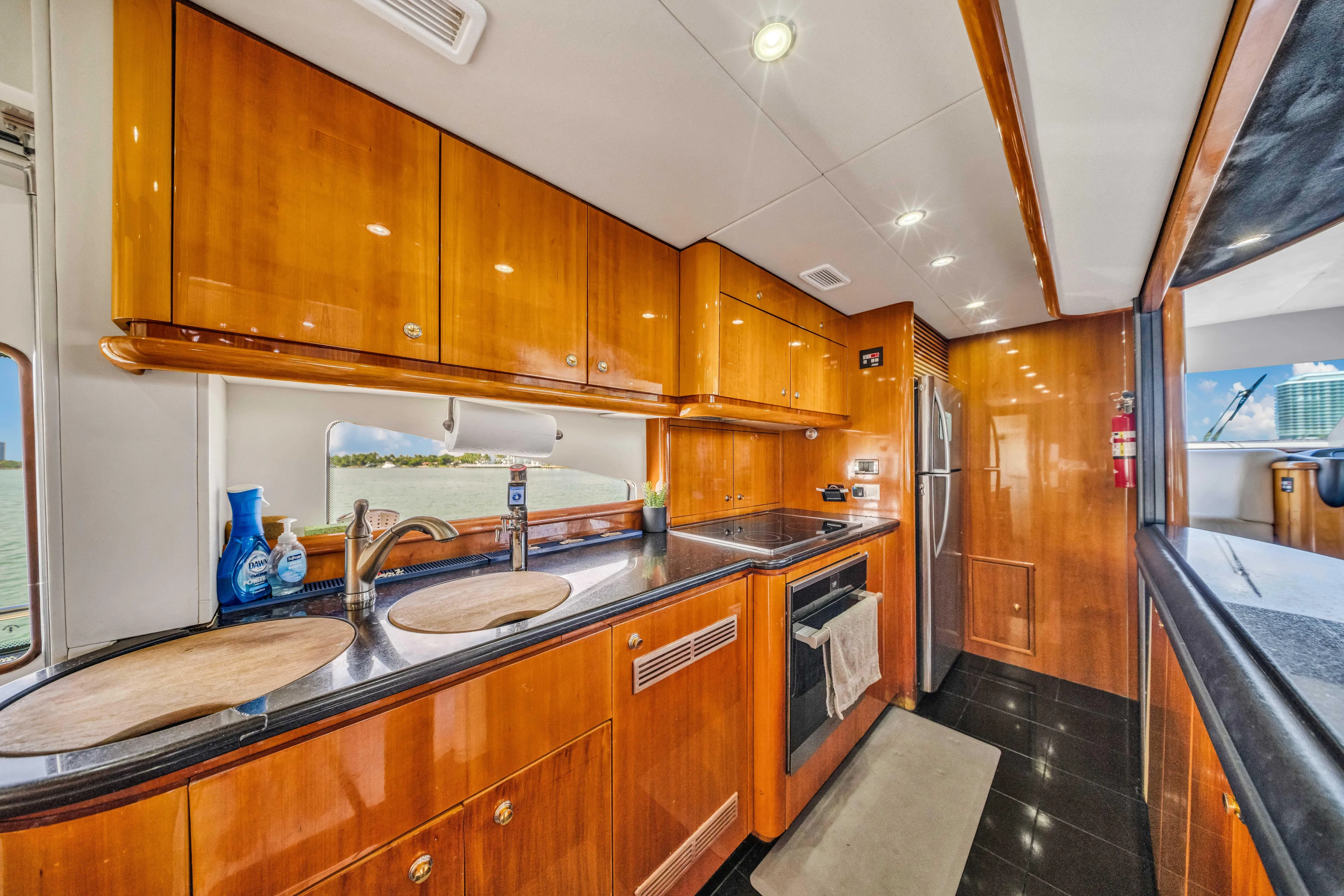 So What Who Cares Yacht Photos Pics Luxurious kitchen interior of 2003 Sunseeker 150 GT yacht with wooden cabinetry.